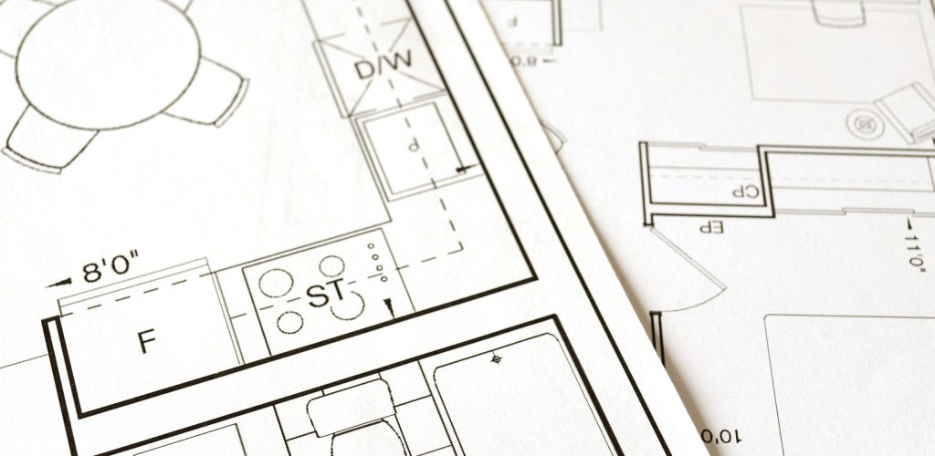 Close-up view of an architectural floor plan on paper showcasing detailed room layouts and measurements.