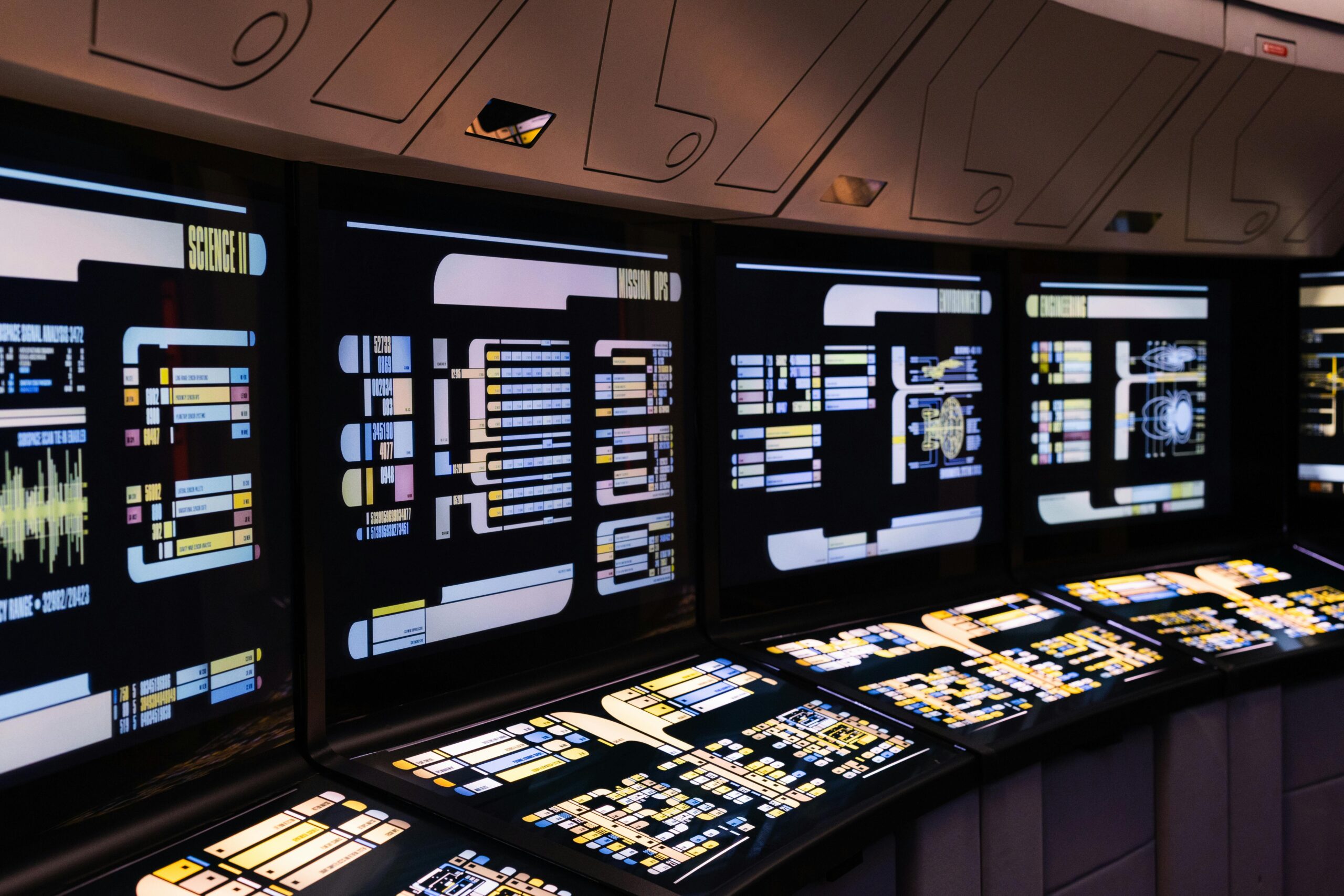 A high-tech command center with illuminated digital screens in a futuristic setting.